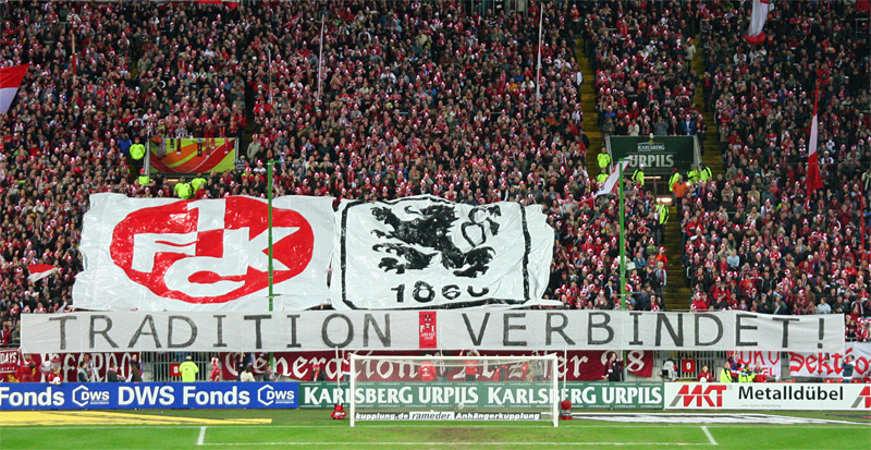 Fanfreundschaft zweier ehemaliger Meistermannschaften: Anhänger:innen des 1. FC Kaiserslautern und des TSV 1860 München am 12. März 2007.  Foto: Thomas Hilmes / http://www.der-betze-brennt.de.  Lizenz: CC BY-SA 3.0 de